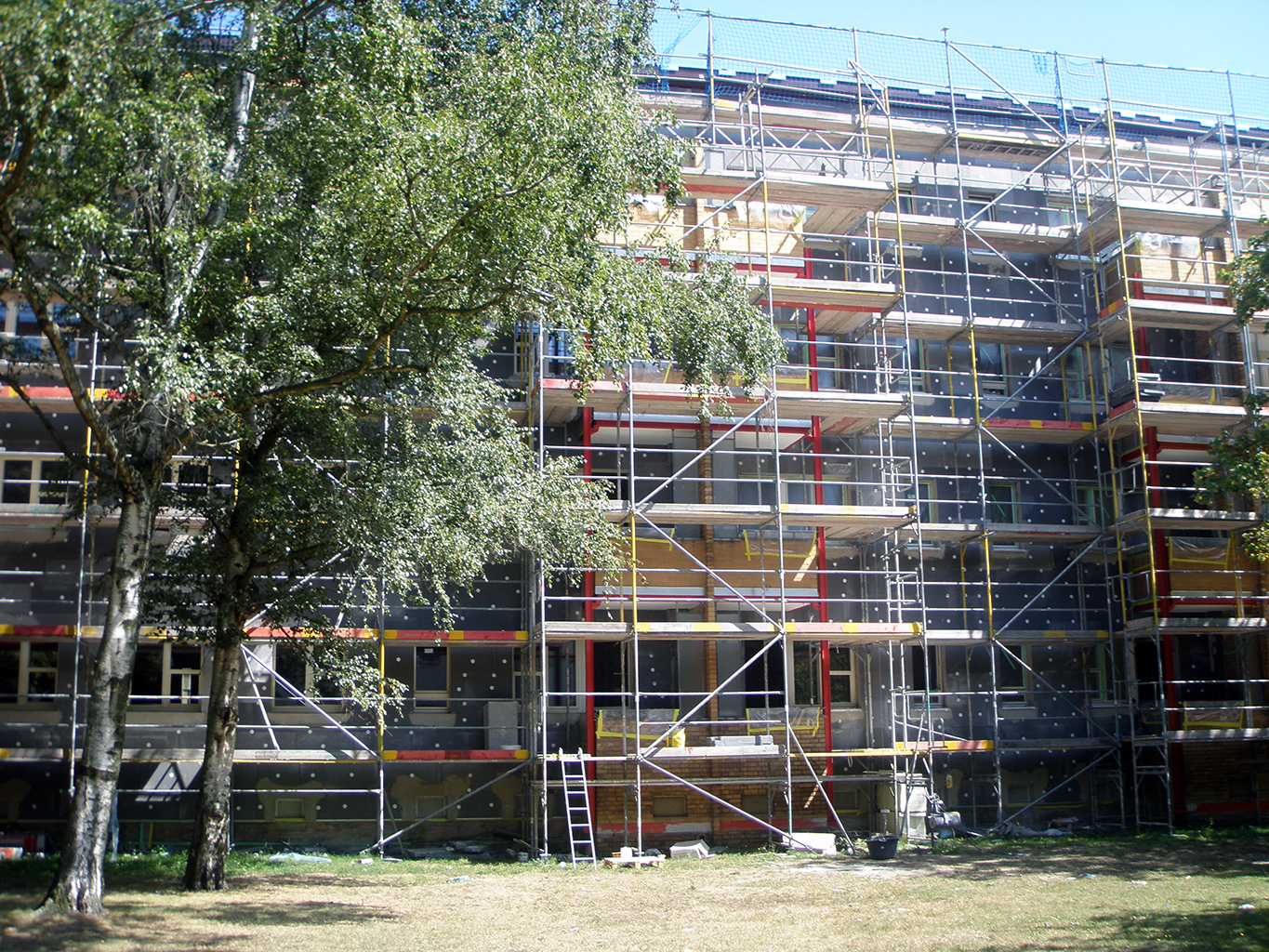 Großer Wohnblock mit Gerüst während der Dämmarbeiten