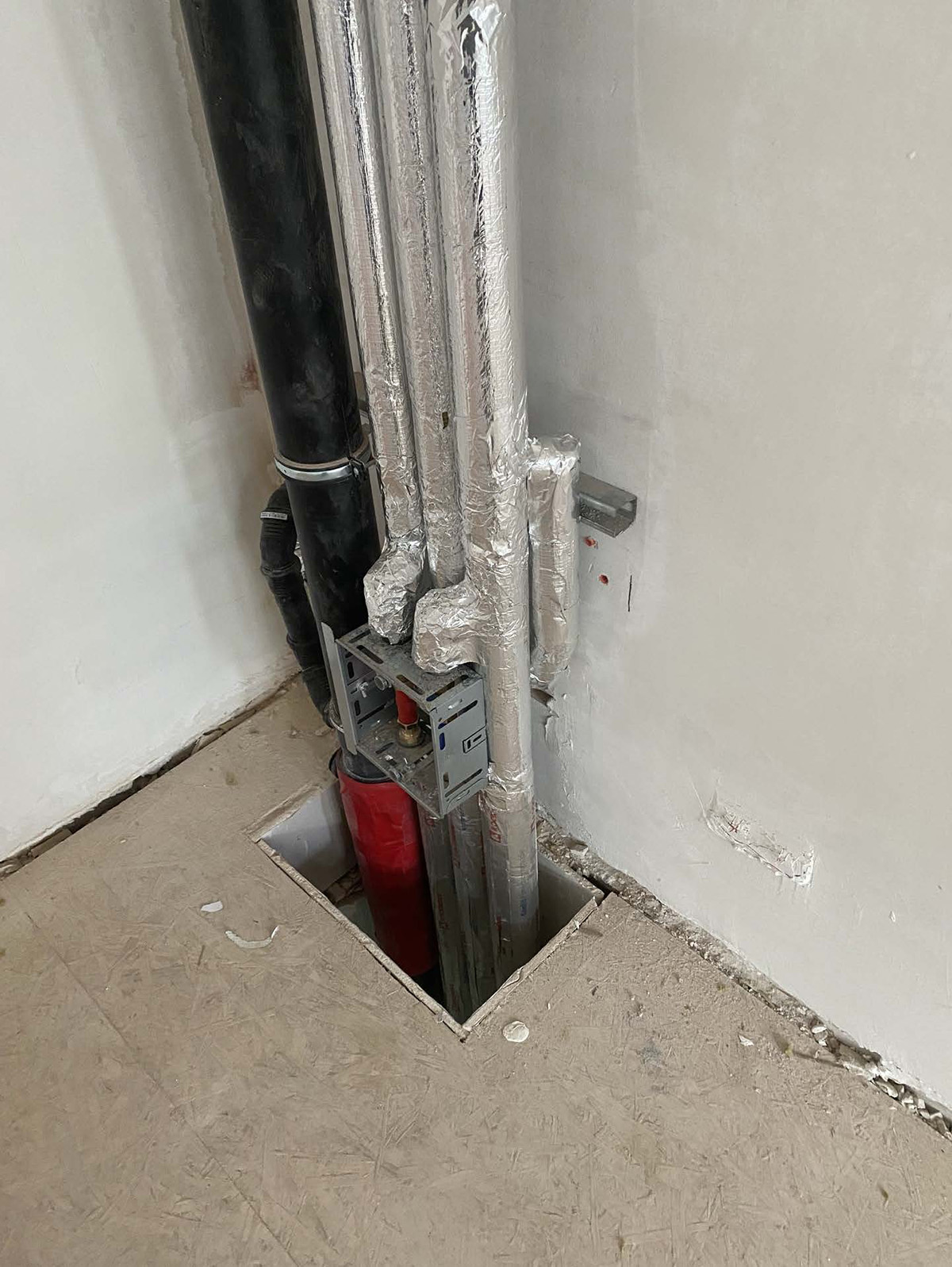 Vertikaler Rohrschacht mit isolierten silbernen Rohren